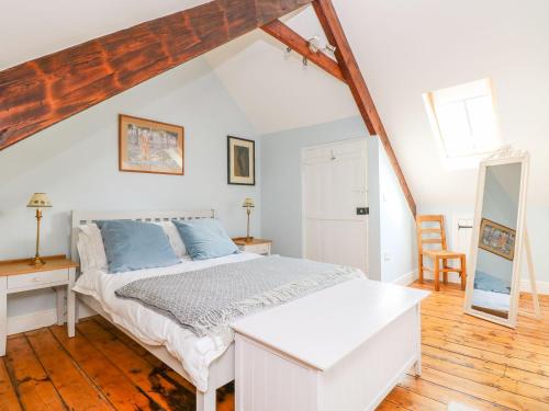a bedroom with a white bed and a wooden floor at 1 Bank Terrace in Newport