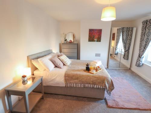 a bedroom with a large bed and a table at Olive Tree Cottage in Louth