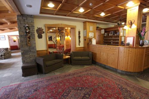 a lobby with chairs and a bar and a rug at Hotel Alpechiara in Pré-Saint-Didier