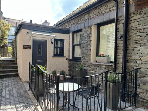 a table and chairs in front of a house at Grayling Cottage in Ambleside