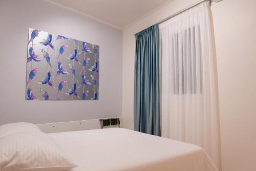 1 dormitorio con cama blanca y ventana en Centrale cozy home, en Ioannina