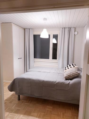 um quarto com uma cama grande e uma janela em Kotirinne 135 - järven rannalla em Jyväskylä
