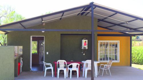 un patio con mesa y sillas bajo un techo en Casa Doña Nelly - Sierras, naturaleza, y descanso en Villa Yacanto