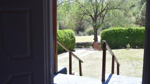 una puerta abierta con vistas a un patio con arbustos en Casa Doña Nelly - Sierras, naturaleza, y descanso en Villa Yacanto