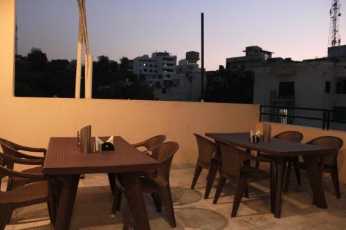 two tables and chairs on the roof of a building at Maruti Group of Hotels - Shri Naman in Nāthdwāra