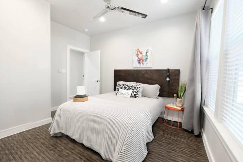 a white bedroom with a bed and a window at The Kozy Urban Dallas Flat in Dallas