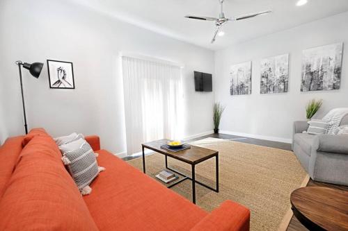 a living room with an orange couch and a table at Global Cup The Kozy Urban Dallas Flat in Dallas