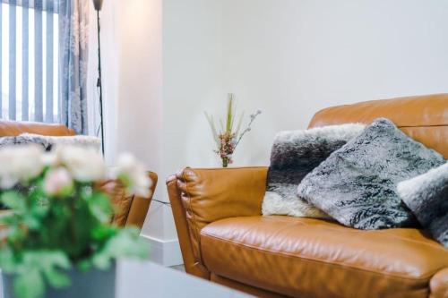uma sala de estar com um sofá de couro e uma mesa em Luxury Modern House In The Heart of Manchester em Manchester