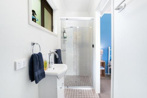 a white bathroom with a shower and a sink at Laurelview Gympie in Gympie