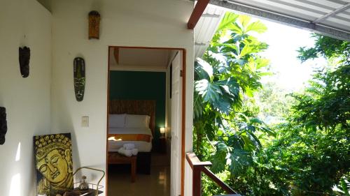 a room with a bed and a door leading to a bedroom at Osa de Rio in Uvita