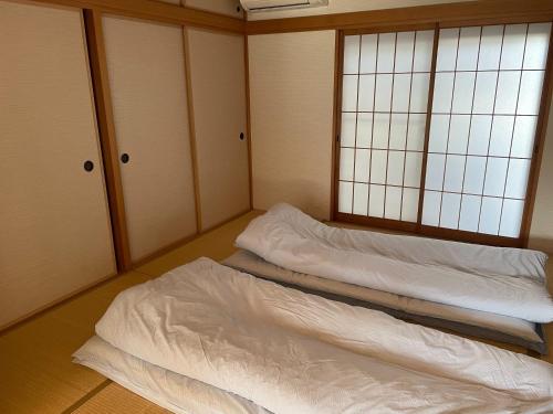 2 Betten in einem Zimmer mit weißer Bettwäsche in der Unterkunft Azuma Taku - Vacation STAY 13741 in Kanie
