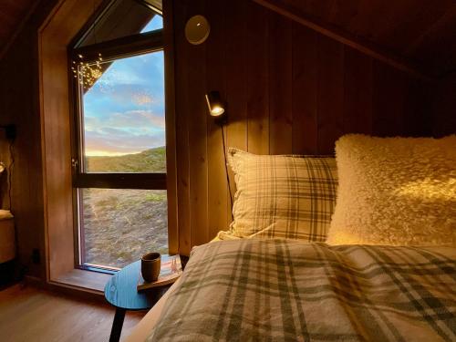 a bedroom with a bed and a window at The Magic View - Nature and Sea in Sørvågen