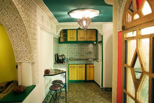 een keuken met een tafel en een fornuis in een kamer bij Dar Ayour appartements in Essaouira