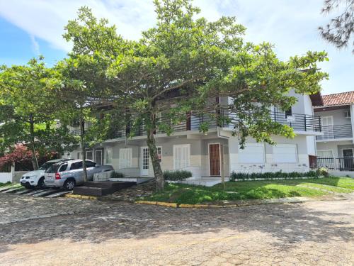 une maison avec une voiture garée devant elle dans l'établissement RESIDENCIAL COM CASAS DE 3 DORM, à Garopaba