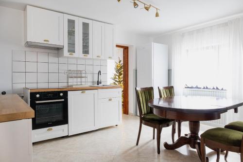 a kitchen with a table and a kitchen with white cabinets at Holiday House Smilja in Ogulin