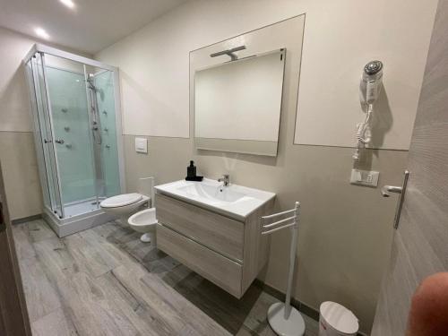 a bathroom with a sink and a toilet and a mirror at Rent room Iacopo in Capannori