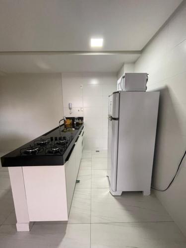 a white kitchen with a stove and a refrigerator at Mardisa Design by Jess Hospedagens in João Pessoa