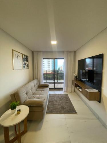 a living room with a couch and a flat screen tv at Mardisa Design by Jess Hospedagens in João Pessoa