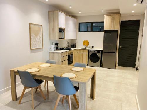 una cucina con un tavolo di legno e sedie blu di Zimbali Lakes Boulevard Royal Suite 116 a Ballito