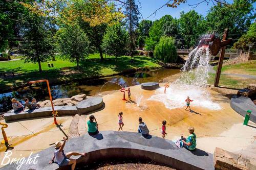 a group of people playing in a water park at REDGUM RETREAT BRIGHT - Luxury Spa Villa in Bright