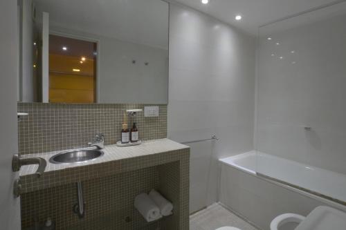 La salle de bains est pourvue d'un lavabo et d'une baignoire. dans l'établissement Minimalist design apartment with amazing view, à Buenos Aires