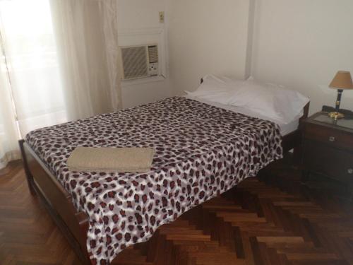 a bedroom with a bed with a black and white blanket at Edificio Columbia in Asunción