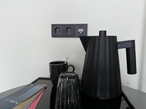 a black coffee maker sitting on top of a desk at The Grey Design Hotel in Dortmund