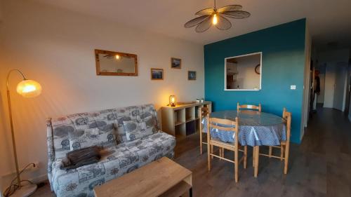 un salon avec un canapé et une table dans l'établissement Océane Flore appart vue mer, à Les Sables-dʼOlonne