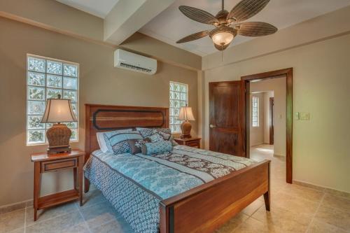 um quarto com uma cama e uma ventoinha de tecto em Placencia Pointe Townhomes #8 em Placencia Village