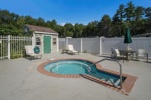 a swimming pool with a table and chairs and a fence at Moody Beach Camping Resort Loft Park Model 14 in Moody