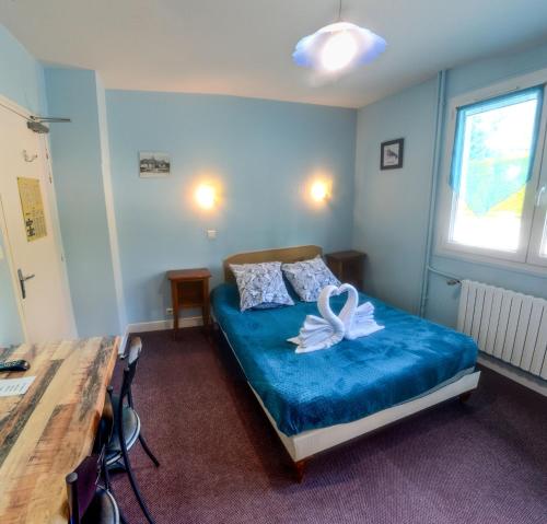 ein kleines Zimmer mit einem Bett mit einer Blume darauf in der Unterkunft Hôtel Le Pommeil in Guéret