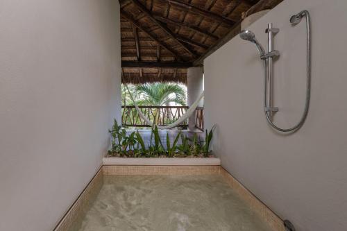 a walk in shower in a room with plants at Ana y Jose Hotel & Spa Tulum in Tulum