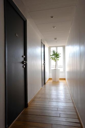 a hallway with a door and a potted plant at Hôtel de France in Aix-en-Provence