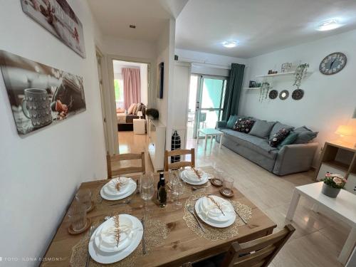 a dining room and living room with a table and chairs at Apartamento Isla Feliz in Golf del Sur Cozy Apartment with Terrace, Pool & Parking in San Miguel de Abona