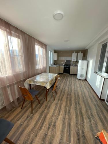 a room with a table and chairs and a kitchen at Riverside Rancho guest house in Lermontovo