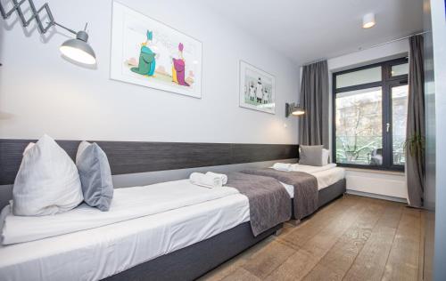 um quarto com 2 camas e uma janela em InPoint Downtown Large Apartments near Market Square & Kazimierz em Cracóvia