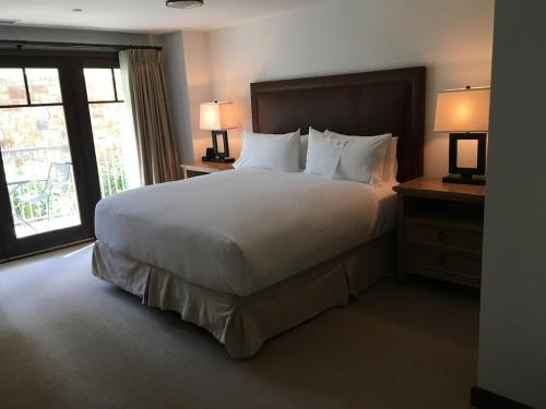 - un grand lit dans une chambre d'hôtel avec 2 lampes dans l'établissement Luxury Residence at a 5 Star Hotel at the Heart of Mountain Village - Telluride, à Telluride