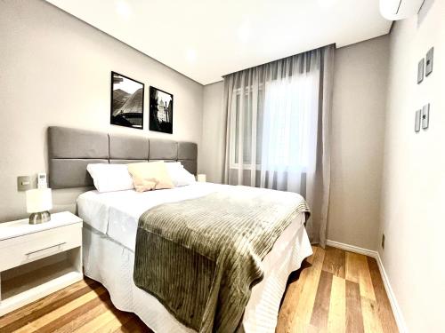 a bedroom with a large bed and a window at Flat 2 quartos a 2 quadras da paulista com garagem in São Paulo