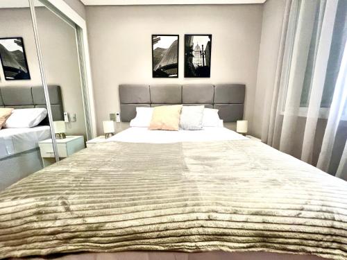 a bedroom with a large bed with two mirrors at Flat 2 quartos a 2 quadras da paulista com garagem in São Paulo