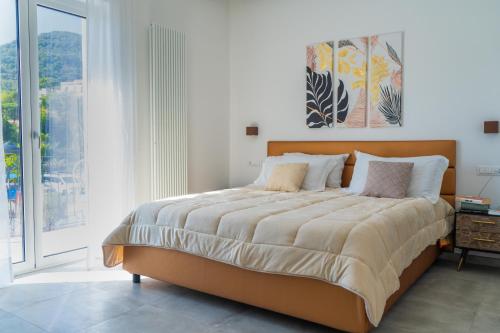 a bedroom with a large bed and a large window at Alloggio nuovissimo al centro e rilassante in Ischia