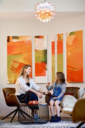 a woman and a little girl sitting on a table at Sojourn Apartment Hotel - Ghuznee in Wellington