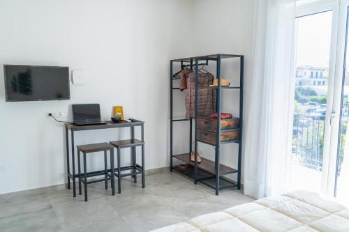 a room with a table and a desk with a laptop at Alloggio nuovissimo al centro e rilassante in Ischia