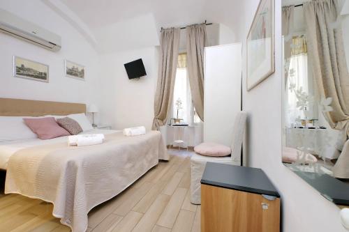 a white bedroom with two beds and a mirror at Dream City Rome in Rome