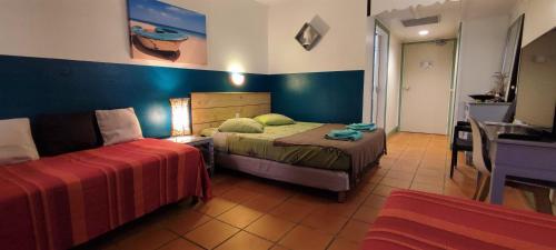 ein Schlafzimmer mit einem Bett und einem Sofa darin in der Unterkunft Cactus Anse Des Rochers in Saint-François