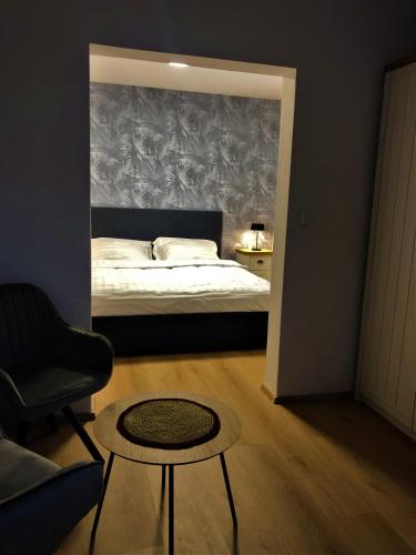 a bedroom with a bed and a table and a chair at Lady Apartments in Liberec