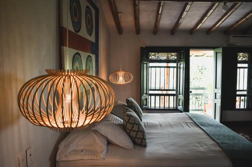 a bedroom with a bed with pillows and a light fixture at Hacienda Bambusa in El Caimo