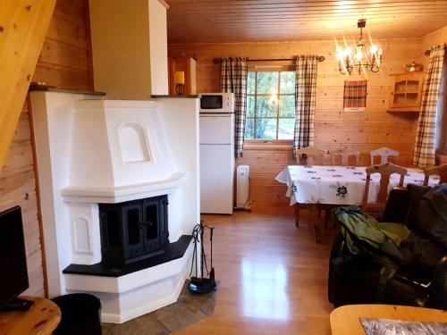 a living room with a fireplace and a kitchen with a table at Stalheim Fjord og Fjellhytter in Stalheim