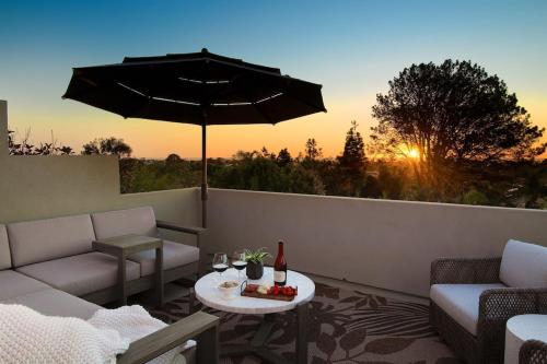 a patio with couches and an umbrella and a table at Grandview Getaway, Luxury 4BR, Ocean View, Fire Pit in Encinitas