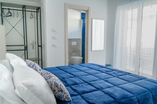 a blue bed in a room with a window at Alloggio nuovissimo al centro e rilassante in Ischia