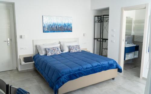 a bedroom with a bed with a blue comforter at Alloggio nuovissimo al centro e rilassante in Ischia
